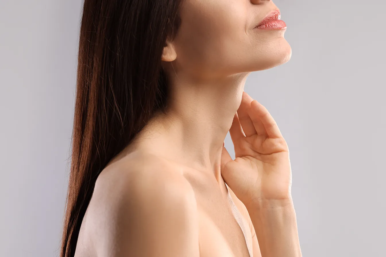 Woman showing a defined jawline and smooth neck contour.